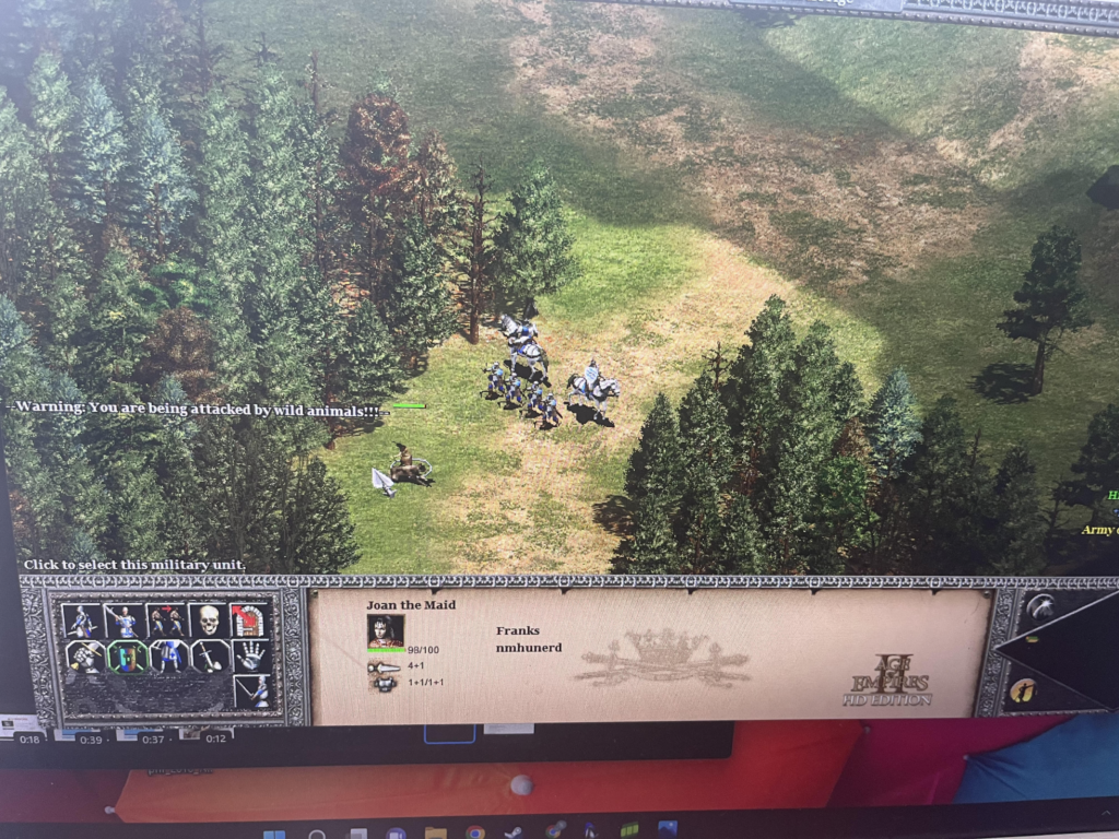 A screenshot from Age of Empires 2 showing Joan of Arc fighting a wild boar